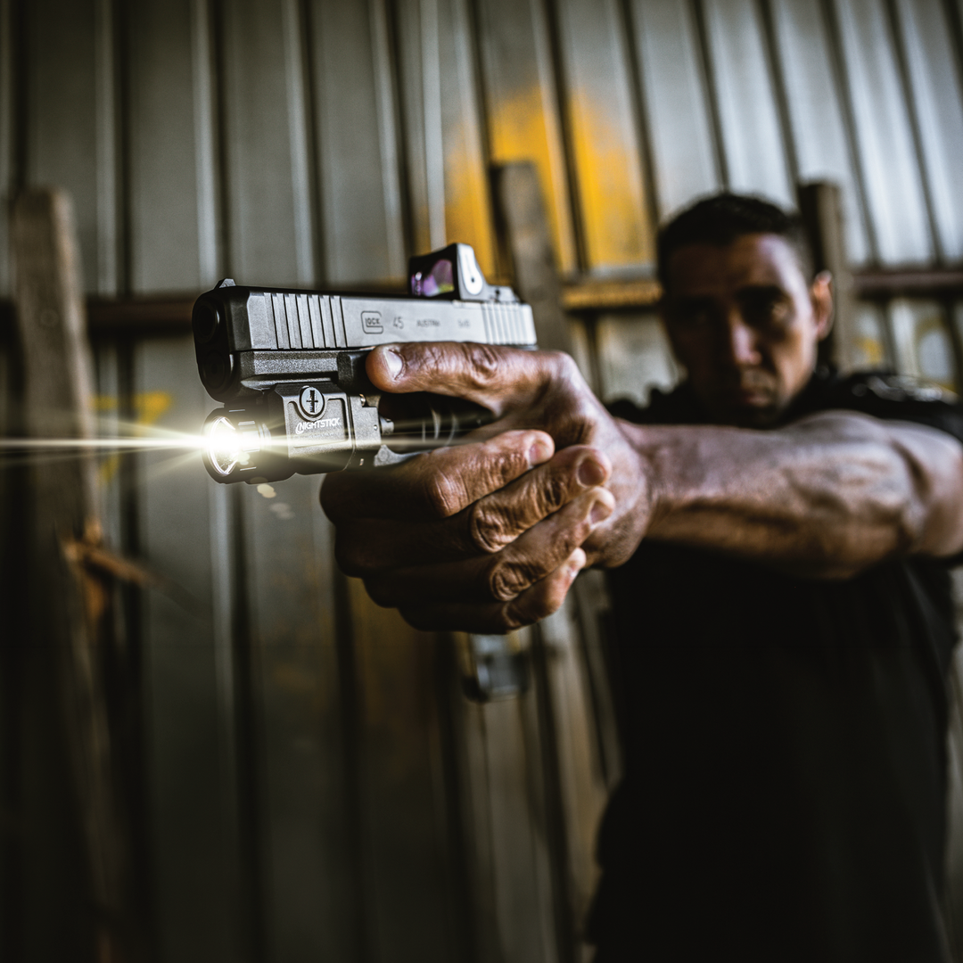 Person holding a handgun with a blurred background