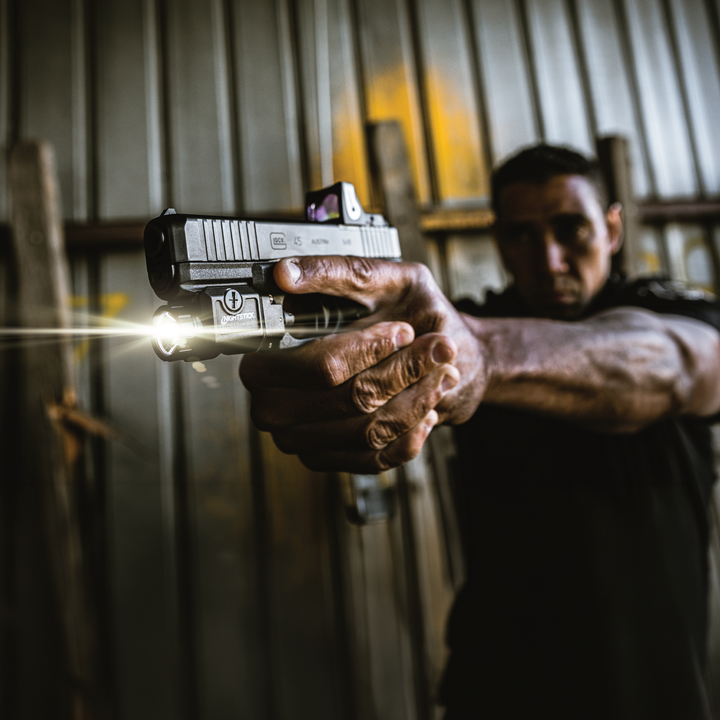 Person holding a handgun with a blurred background