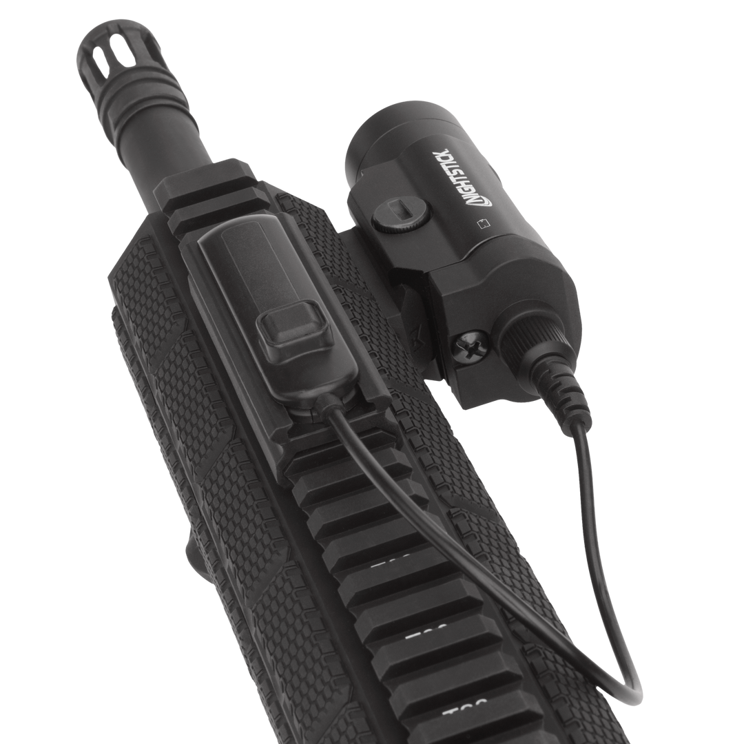 Black tactical flashlight attached to a gun stock on a white background