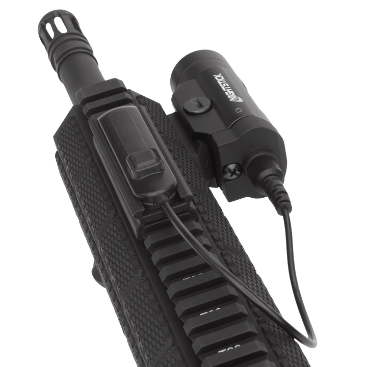 Black tactical flashlight attached to a gun stock on a white background