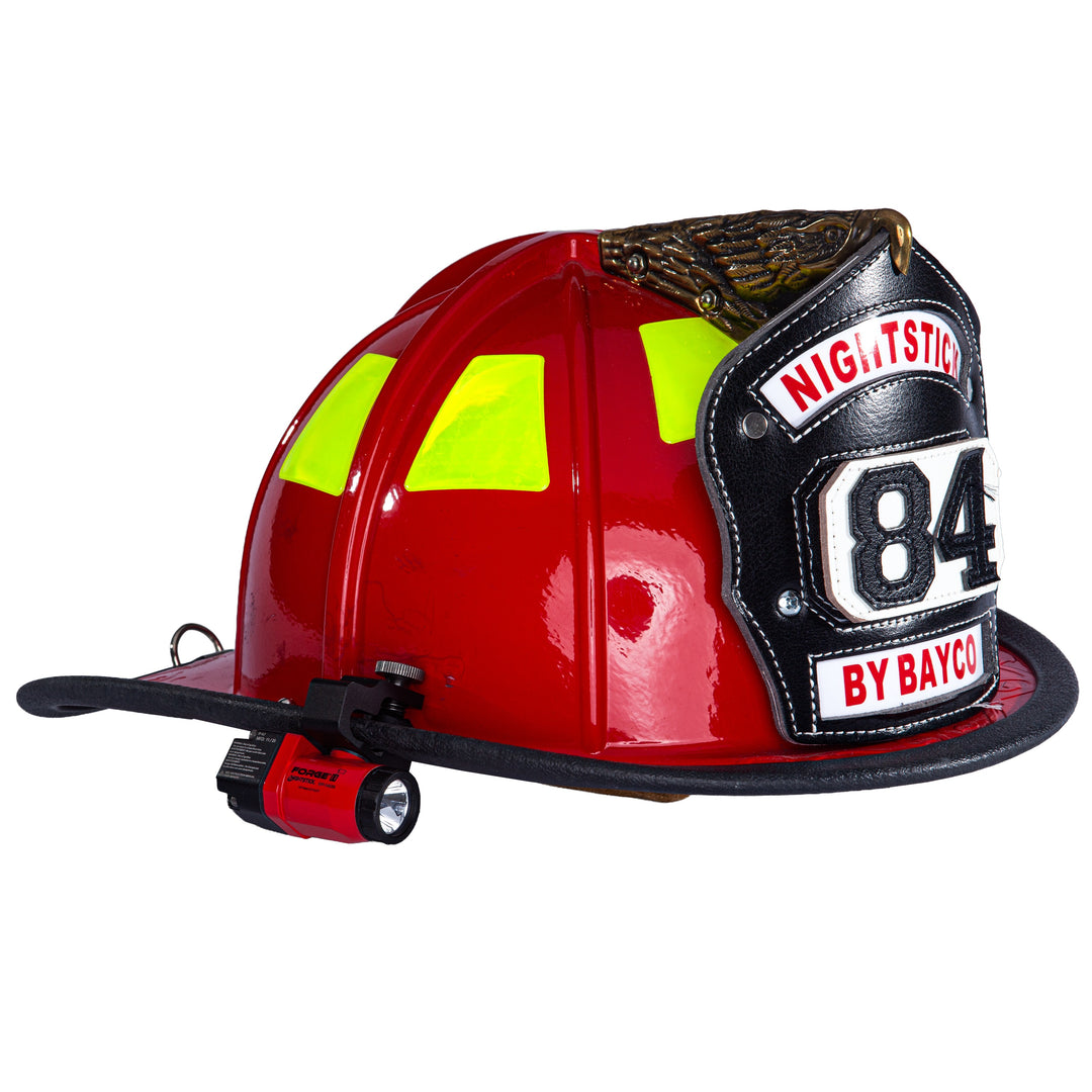 Red fire helmet with yellow reflective stripes and 'Nightstick 84 by Bayco' branding on a white background