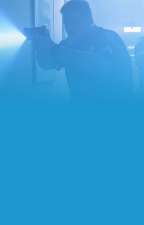 Police officer with weapon drawn and light on